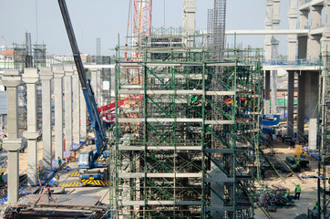 Asian people and thai workers with heavy machinery working builder new building at construction site high-rise building on scaffold at Bangkok, Thailand.