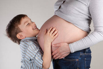 Portrait of happy pregnant mother and son