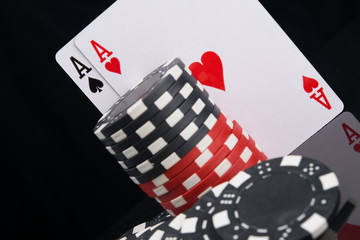 Obraz premium two aces and a stack of chips to play in the casino, standing on a black background