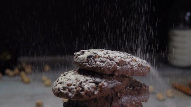 Slow motion shot hands of cookie adding powdered sugar on the peice pie as a topping 