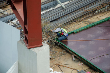 Asian thai people worker welding steel in construction site making reinforcement metal framework for concrete pouring in Nonthaburi, Thailand