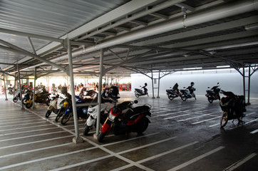 Thai people and travelers ride to stop in motorcycle and bicycle parking building of department store and supermarket mall at Bangkok, Thailand.