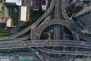 Aerial top down view on busy multilevel interchange overpass in Shanghai showing afternoon traffic...