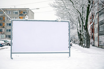 Billboard mockup poster stand in the street. Winter, snow and cold