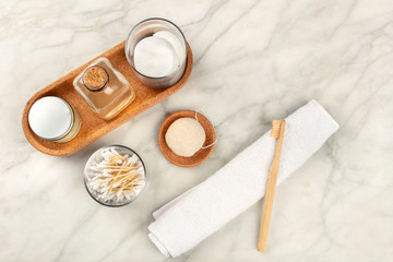 Sustainable toiletries. Homemade lotions, cotton pads, bamboo toothbrush, natural Konjac sponge, and biodegradable bamboo cotton swabs, shot from above