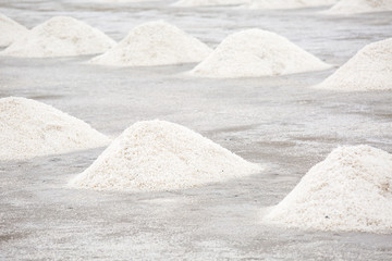 Heap of sea salt in a field prepared for harvest. Raw salt pile before delivery to the factory. The sea that is dried to become salt.