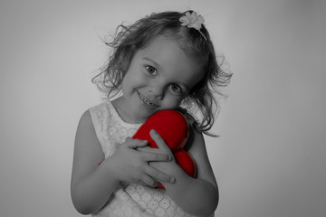Kleines Mädchen mit rotem Herz in der Hand