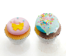 Pink and blue cupcakes on white background. For small parties.