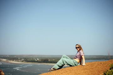 Beautiful girl relaxing on sea rocks