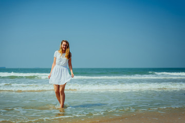Fototapeta na wymiar Beautiful Girl in White Dress Enjoy and Relax on The Beach. Travel and Vacation.