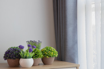 wood table with decoration flowers on white curtain window texture background.