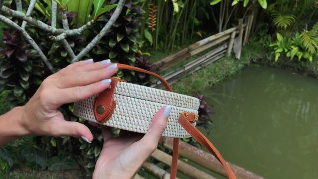 Closeup of stylish handmade rattan handbag on a tropical background. Bali island.
