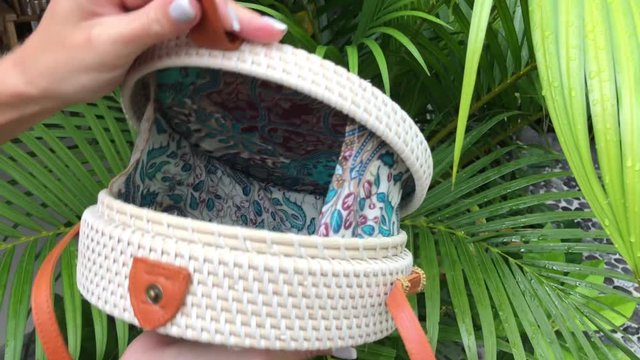 Closeup of stylish handmade rattan handbag on a tropical background. Bali island.