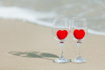 glass of red heart wine on the beach
