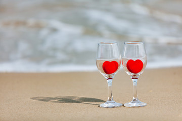 glass of red heart wine on the beach
