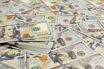 A pile of one hundred US banknotes with president portraits. Cash of hundred dollar bills, dollar background image with high resolution.