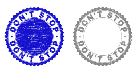 Obraz premium Grunge DON'T STOP watermarks isolated on a white background. Rosette seals with grunge texture in blue and grey colors. Vector rubber stamp imprint of DON'T STOP text inside round rosette.