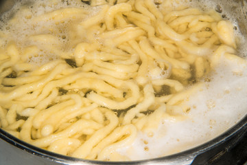 German noodles called Spaetzle cooking in a pot