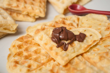 closeup of waffle in shaped heart with chocolate in a white plate