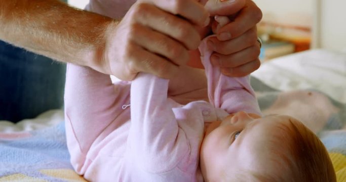 Close-up of of caucasian father playing with baby on bed in a comfortable home 4k