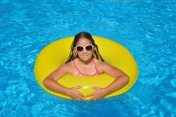 Real adorable girl relaxing in swimming pool