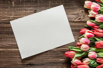 Fresh flower, mockup. Background for mothers day with card of paper and flowers - birthday bouquet of tulip, flat lay, top view on wooden table.