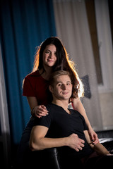 Obraz premium Young pretty smiling couple sitting on a couch in a living room