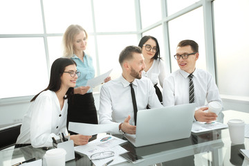 business people working and communicating while sitting at the office desk