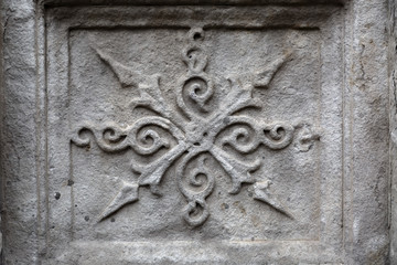 Close-up: stone element of an old ornament on the collapsing wall of an ancient temple