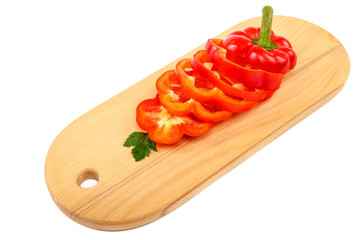 Slices of sweet pepper on a cutting wooden board.