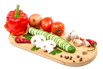 Slices of fresh vegetables on a cutting wooden board