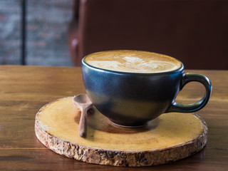 Hot latte art coffee in cup on wood table