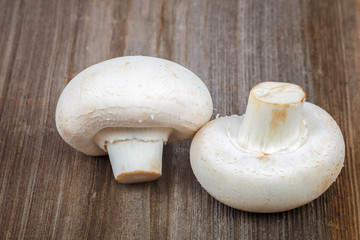 Button mushrooms on the a wooden background.