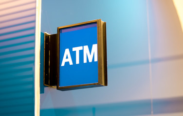 Modern square shape ATM sign in department store. White text on blue background.
