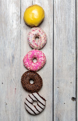 colorful, sweet, iced fresh donuts in a row on bright background