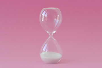 Hourglass on pink background - Concept of infertility and biological clock in women