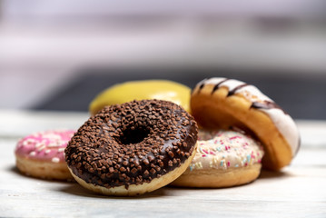 colorful, sweet, iced fresh donuts on bright background
