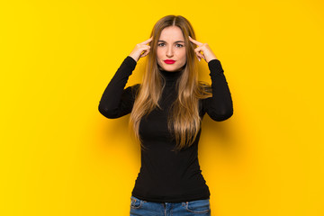 Young pretty woman over yellow background having doubts and thinking