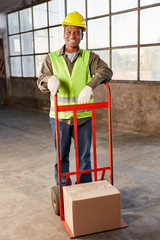 Junger Logistik Arbeiter transportiert ein Paket