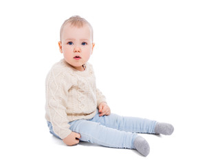 portrait of cute baby girl in winter clothes sitting isolated on white