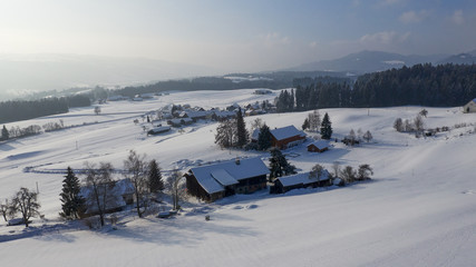 aerial flight over snow covered german village in winter