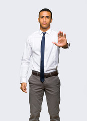 Young afro american businessman making stop gesture denying a situation that thinks wrong on isolated background