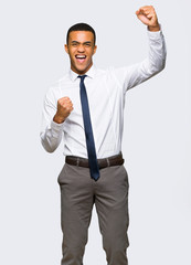 Young afro american businessman celebrating a victory on isolated background