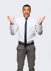 Young afro american businessman with surprise and shocked facial expression on isolated background