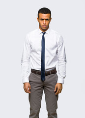 Young afro american businessman with sad and depressed expression on isolated background