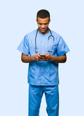 Surgeon doctor man sending a message with the mobile on isolated background