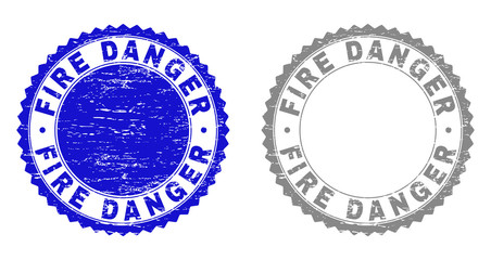 Grunge FIRE DANGER stamp seals isolated on a white background. Rosette seals with distress texture in blue and gray colors. Vector rubber stamp imitation of FIRE DANGER caption inside round rosette.
