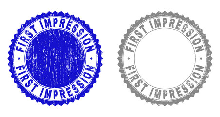 Grunge FIRST IMPRESSION stamp seals isolated on a white background. Rosette seals with grunge texture in blue and grey colors.