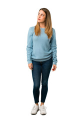 Full body of Blonde woman with blue shirt looking up with serious face on white background