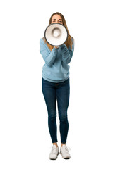 Full body of Blonde woman with blue shirt shouting through a megaphone to announce something on...